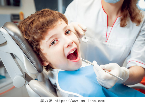 牙科医生在给小男孩看牙牙科办公室的小男孩。平静和快乐